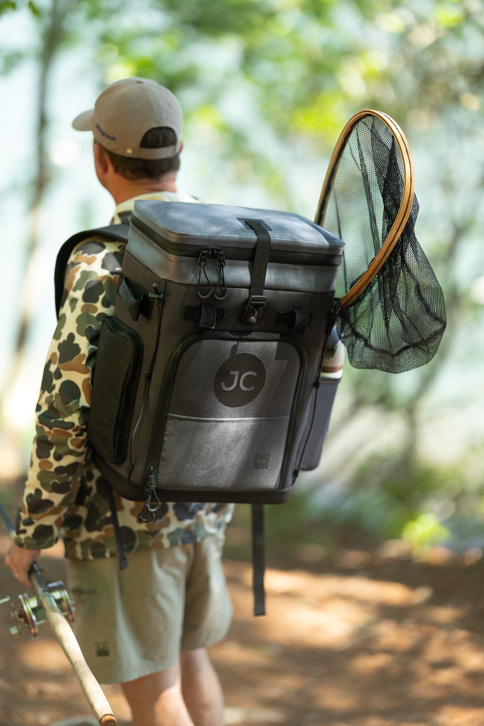 Person with a JC Convertible Backpack and fishing gear walking outdoors