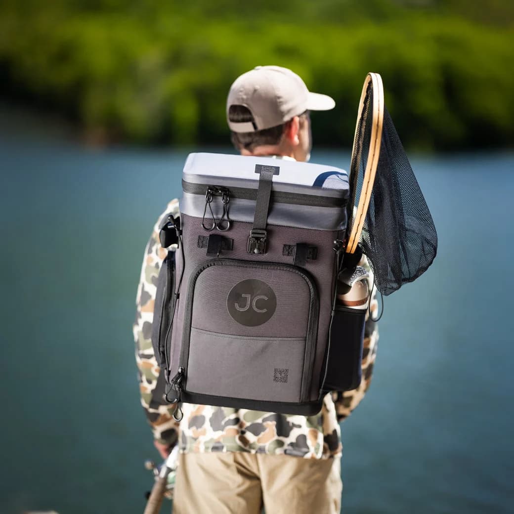 A man carrying the JustinCASE on his back at the water's edge